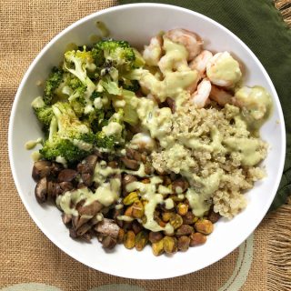 Made with roasted broccoli, shrimp and mushrooms, served with quinoa and a creamy pistachio yogurt, this buddha bowl is bursting with nutrients and yummy flavors! Recipe at Teaspoonofspice.com #buddhabowls #pistachios #shrimp #proteinbowls